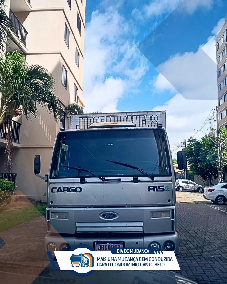 Caminhão baú com o nome Jorge Mudanças parado em frente a um prédio do condomínio Canto Belo